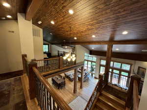 Stairs with wood ceiling, recessed lighting, wood finished floors, and a chandelier