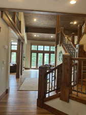 Living room featuring hardwood / wood-style floors, stairway, recessed lighting, beamed ceiling, and a high ceiling