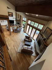 Living area featuring a fireplace, wooden ceiling, wood finished floors, and vaulted ceiling