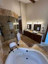 Bathroom with a garden tub, a shower stall, double vanity, and a high ceiling