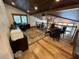 Living room with vaulted ceiling, light wood-style flooring, wooden ceiling, recessed lighting, and a desk