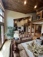 Living room featuring wooden ceiling, wood finished floors, high vaulted ceiling, and recessed lighting