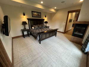 Bedroom featuring a glass covered fireplace and recessed lighting