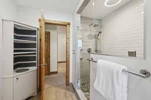 Bathroom featuring a shower stall and light wood-style floors