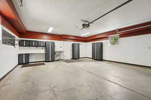 Garage featuring baseboards and a garage door opener