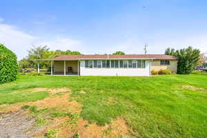 Rear view of property with a patio and a lawn