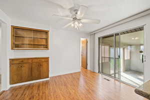 Unfurnished living room featuring light wood-style floors and a ceiling fan