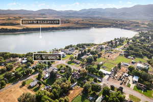 Aerial view of property and surrounding area featuring a water and mountain view and nearby suburban area