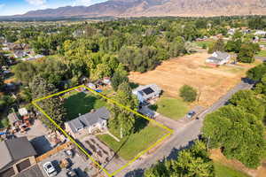 Aerial view of residential area with a mountain backdrop and property boundaries highlighted