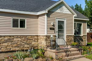 View of front of property with stone siding and a shingled roof