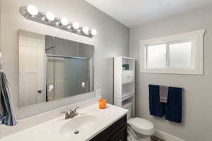 Full bath with vanity, a stall shower, and a textured ceiling