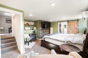 Bedroom featuring a barn door, carpet, a wall mounted air conditioner, and recessed lighting