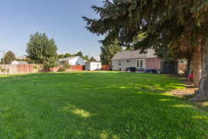 Fenced backyard with a storage shed and a patio area