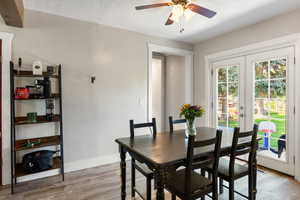 Dining area with light wood-style floors, a textured ceiling, french doors, and ceiling fan