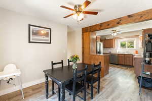 Dining space with light wood-style flooring, ceiling fan, and a textured ceiling