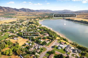 Aerial view of property and surrounding area featuring a water and mountain view and nearby suburban area