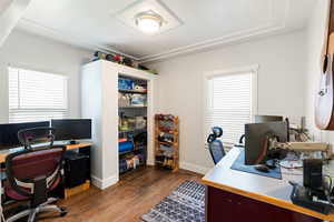 Home office featuring dark wood-style flooring and baseboards