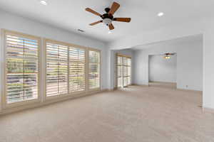 Carpeted empty room with a ceiling fan and recessed lighting