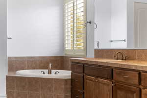 Bathroom featuring a garden tub and vanity