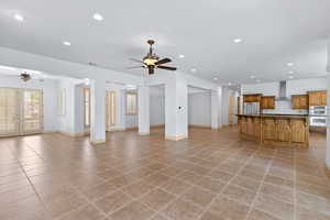 Unfurnished living room with recessed lighting, a ceiling fan, light tile patterned floors, and french doors