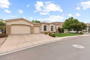 Mediterranean / spanish house with stone siding, stucco siding, and concrete driveway