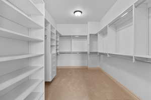 Spacious closet with light colored carpet