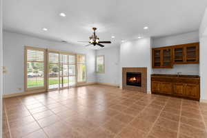 Unfurnished living room with a tile fireplace, recessed lighting, light tile patterned flooring, and a ceiling fan