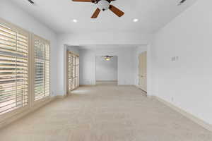 Carpeted empty room with a ceiling fan and recessed lighting
