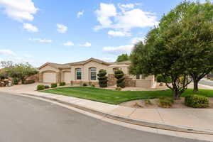 Mediterranean / spanish-style home featuring stone siding, stucco siding, driveway, and a front yard