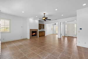 Unfurnished living room with recessed lighting, plenty of natural light, light tile patterned flooring, and a tiled fireplace