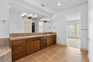 Full bathroom with light tile patterned floors, double vanity, a chandelier, tiled bath, and recessed lighting