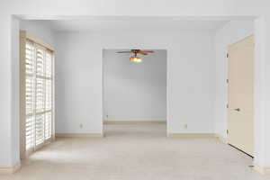 Unfurnished bedroom with light carpet and a ceiling fan