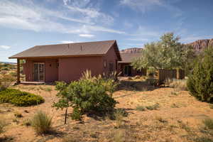 Rear view of property with stucco siding, a metal roof, a mountain view, and a patio area