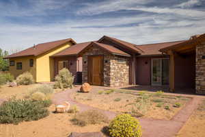 Ranch-style house with stone siding, a metal roof, and stucco siding