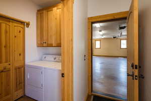 Washroom featuring washer and dryer and cabinet space