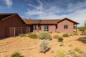 Ranch-style home featuring a metal roof and stucco siding
