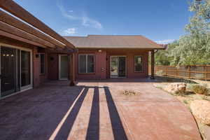 Rear view of house with a metal roof, a patio, and stucco siding