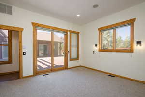 Carpeted bedroom with plenty of natural light and recessed lighting
