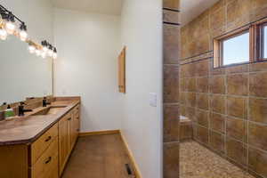 Primary bathroom with vanity and tiled shower