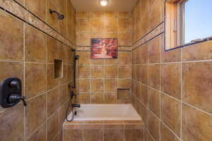 Primary bathroom with tiled shower / bath combo