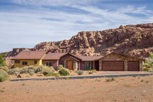 View of front of property with stone siding, a metal roof, a garage, and a mountain view