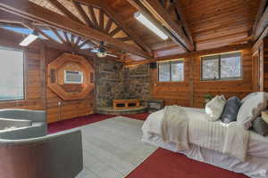 Bedroom featuring a stone fireplace, wood walls, wooden ceiling, and vaulted ceiling with beams featuring a pull down Murphy bed