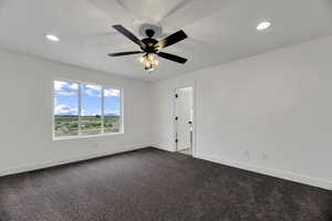 Empty room with dark colored carpet, recessed lighting, and ceiling fan