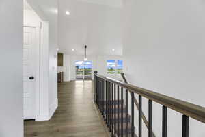 Hall featuring recessed lighting, light wood-style flooring, an upstairs landing, and lofted ceiling
