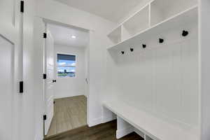 Mudroom with dark wood-type flooring and baseboards