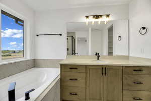 Full bath featuring a stall shower, vanity, and a garden tub