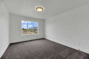 Carpeted spare room with a mountain view and baseboards