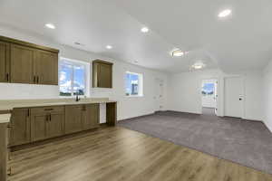 Kitchen with healthy amount of natural light, brown cabinetry, light countertops, and recessed lighting
