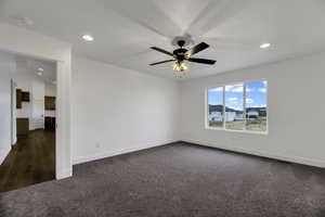 Unfurnished room with dark colored carpet, recessed lighting, and ceiling fan
