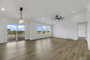 Unfurnished living room with light wood-style flooring, recessed lighting, high vaulted ceiling, and a chandelier